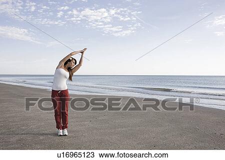 Stock Image - Woman stretching on the shore. Fotosearch