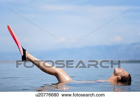 Woman swimming with flippers at beach View Large Photo Image Stock Image - Woman swimming with flippers at beach. Fotosearch