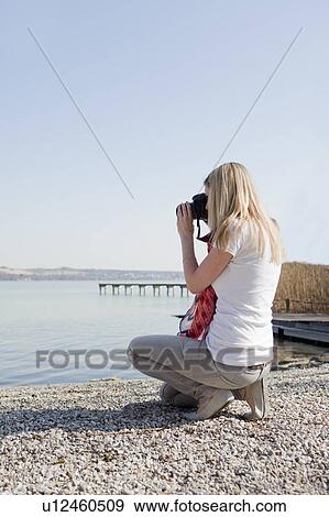 Woman taking pictures at a sea View Large Photo Image Stock Photo - Woman taking pictures at a sea. Fotosearch
