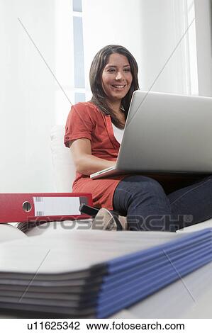 Stock Image - Woman using laptob in home office. Fotosearch