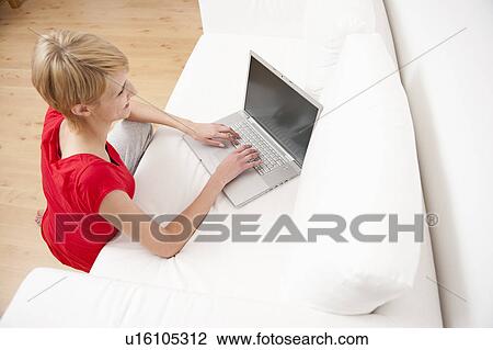 Woman using laptop on sofa View Large Photo Image Stock Image - Woman using laptop on sofa. Fotosearch