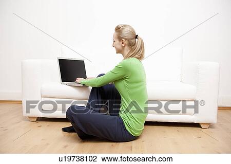 Woman using laptop on sofa View Large Photo Image Stock Image - Woman using laptop on sofa. Fotosearch