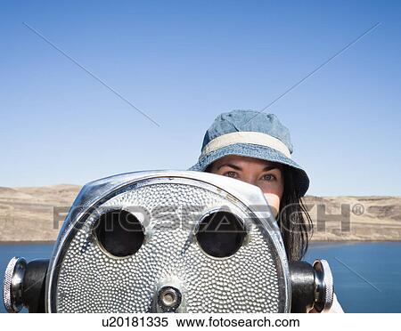 Stock Photography - Woman using telescopic viewer. Fotosearch