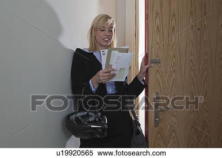 Stock Photography - Woman walking through door with post. Fotosearch