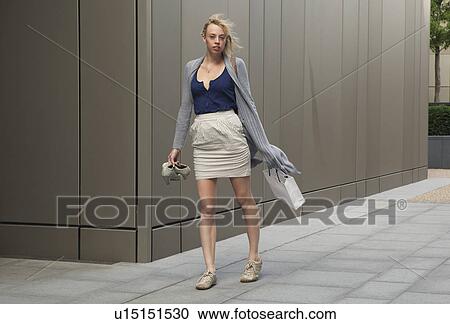 Stock Image - Woman walking with shopping. Fotosearch