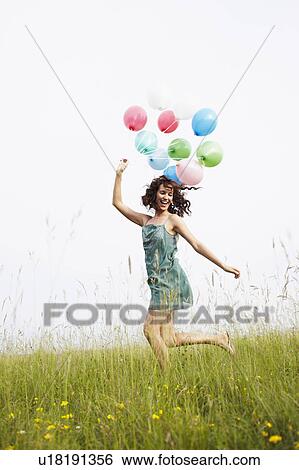 Woman with air balloons jumping View Large Photo Image Stock Photograph - Woman with air balloons jumping. Fotosearch