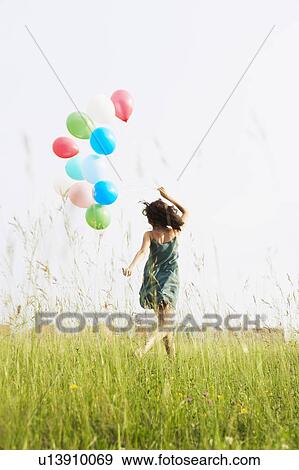 Stock Photo - Woman with balloons running away. Fotosearch