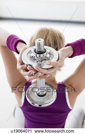 Woman with dumbbell training shoulders View Large Photo Image Stock Image - Woman with dumbbell training shoulders. Fotosearch