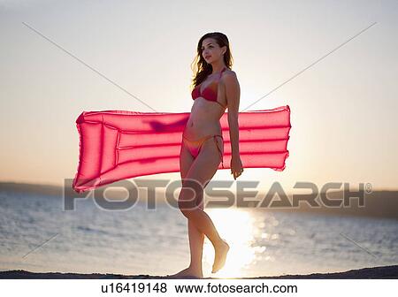 Stock Photo - Woman with inflatable at the beach. Fotosearch