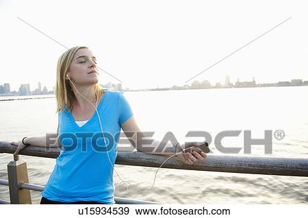 Woman with ipod, by the hudson river View Large Photo Image Stock Photo - Woman with ipod, by the hudson river. Fotosearch
