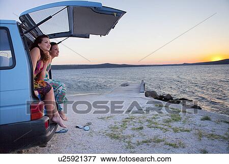 Stock Photo - Women camping in van at the beach. Fotosearch