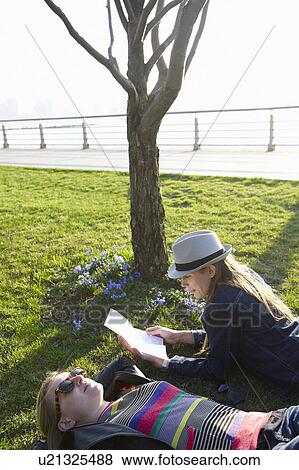 Stock Photo - Women laying on the grass. Fotosearch