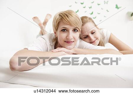 Women lying on bed View Large Photo Image Picture - Women lying on bed. Fotosearch
