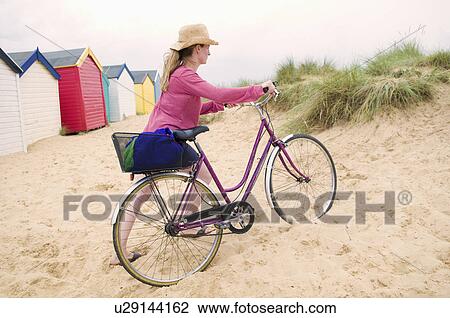 Women pushes bicycle over beach View Large Photo Image Stock Image - Women pushes bicycle over beach. Fotosearch