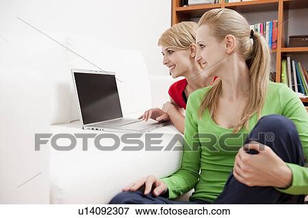 Women using laptop on sofa View Large Photo Image Stock Photo - Women using laptop on sofa. Fotosearch