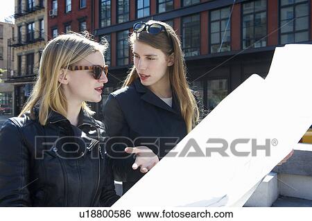 Women walking in the street with a map View Large Photo Image Stock Photograph - Women walking in the street with a map. Fotosearch