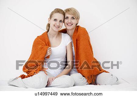 Women wrapped up on blanket sitting on b View Large Photo Image Stock Photo - Women wrapped up on blanket sitting on b. Fotosearch