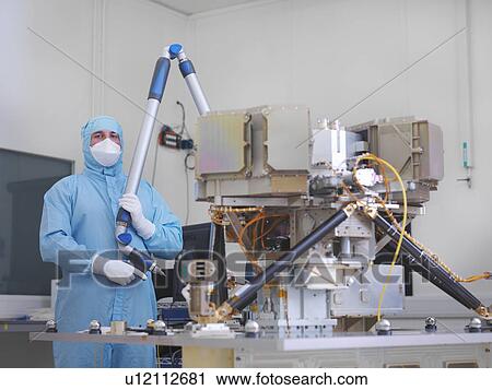 Stock Image - Worker building satellite dish. Fotosearch
