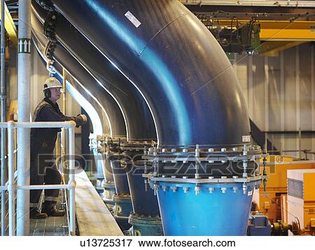 Stock Photo - Worker checking cooling water pipes. Fotosearch