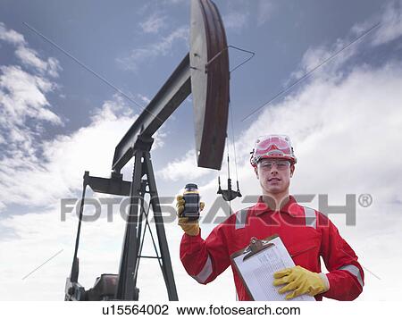 Worker holding crude oil at oil well View Large Photo Image Stock Image - Worker holding crude oil at oil well. Fotosearch