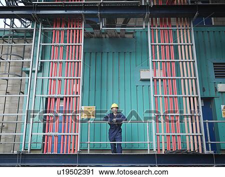 Stock Image - Worker in coal fired power station. Fotosearch
