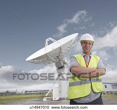 Worker in front of satellite dish View Large Photo Image Stock Image - Worker in front of satellite dish. Fotosearch