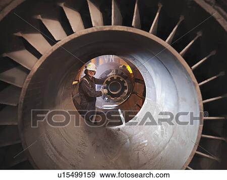 Stock Photo - Worker inspecting coal burner jet. Fotosearch