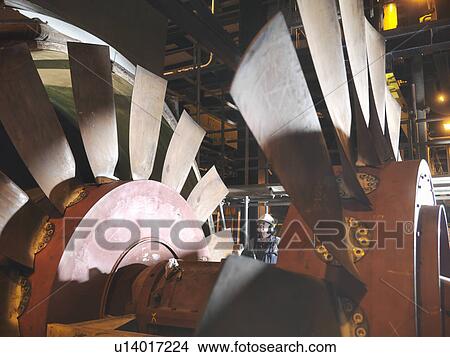 Picture - Worker inspecting cooling fan. Fotosearch