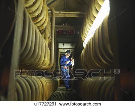 Stock Image - Worker repairing a furnace. Fotosearch