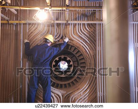 Stock Photo - Worker repairing furnace. Fotosearch
