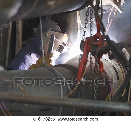Stock Photography - Worker welding in a power station. Fotosearch