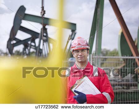 Stock Image - Worker with oil wells. Fotosearch