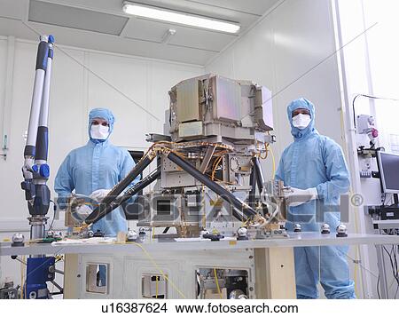 Picture - Workers assembling satellite dish. Fotosearch