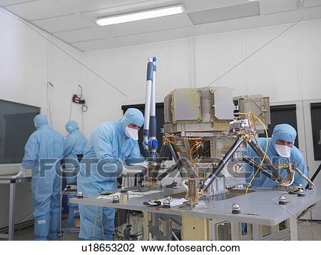 Stock Image - Workers building satellite dish. Fotosearch