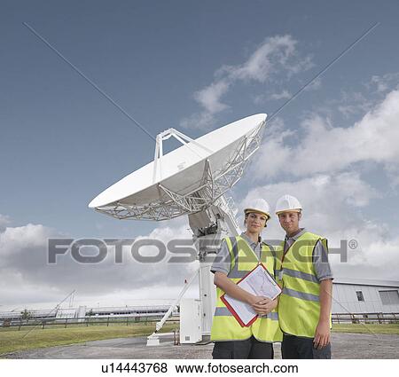Workers in front of satellite dish View Large Photo Image Stock Photo - Workers in front of satellite dish. Fotosearch