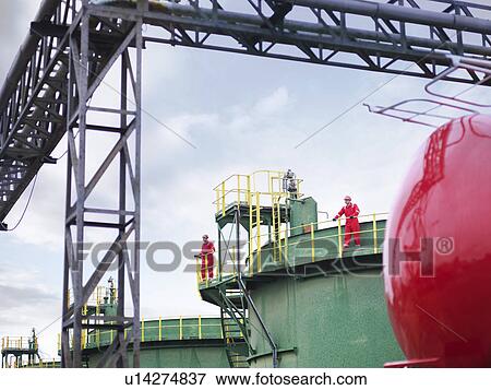 Workers on walkway of oil tank View Large Photo Image Stock Photo - Workers on walkway of oil tank. Fotosearch