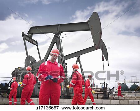 Stock Photo - Workers with oil well pumps. Fotosearch