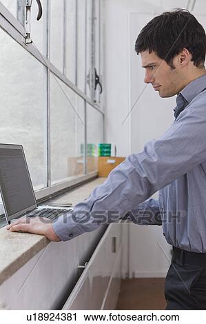Working on laptop by the window View Large Photo Image Stock Image - Working on laptop by the window. Fotosearch