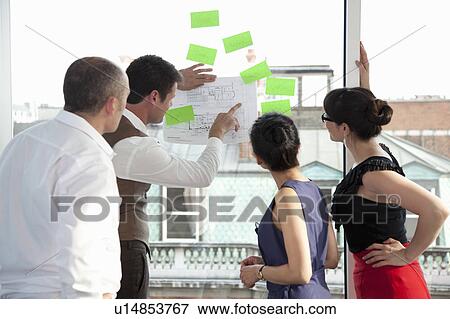 Workmates looking at plans View Large Photo Image Stock Photo - Workmates looking at plans. Fotosearch