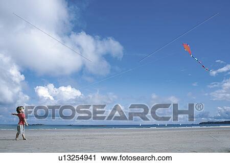 Stock Image - Young boy flying a kite. Fotosearch