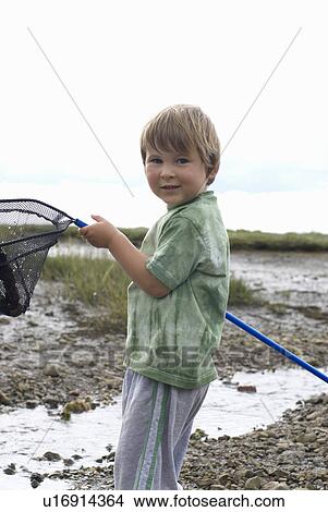 Picture - Young boy holding fishing net up. Fotosearch