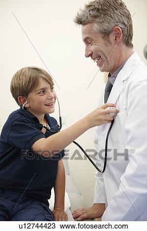 Young Boy listening to doctors heart View Large Photo Image Stock Image - Young Boy listening to doctors heart. Fotosearch