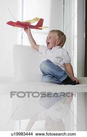 Young boy playing with toy plane View Large Photo Image Picture - Young boy playing with toy plane. Fotosearch