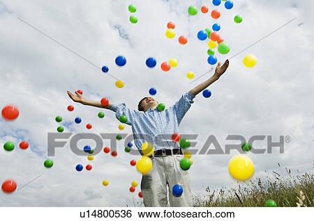 Young boy throwing colored balls View Large Photo Image Stock Photograph - Young boy throwing colored balls. Fotosearch