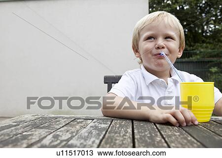 Young Boy trinking juice with a straw View Large Photo Image Stock Image - Young Boy trinking juice with a straw. Fotosearch