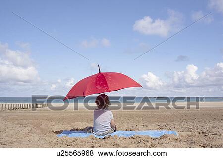 Young boy under a parasol View Large Photo Image Stock Photo - Young boy under a parasol. Fotosearch