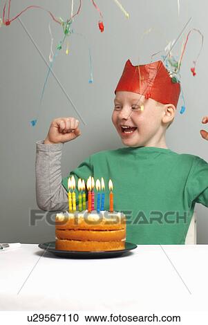 Young boy with cake, party hat, streamer View Large Photo Image Stock Image - Young boy with cake, party hat, streamer. Fotosearch