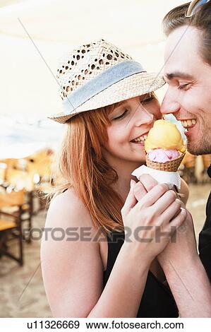 Stock Photo - Young couple eating ice cream. Fotosearch