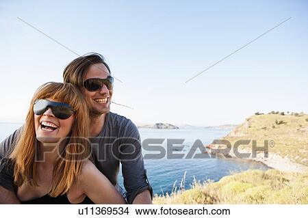 Young couple in front of seaside View Large Photo Image Picture - Young couple in front of seaside. Fotosearch