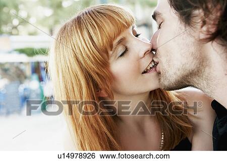 Stock Photograph - Young couple kissing. Fotosearch